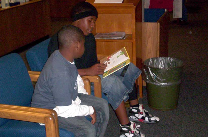 Middle School Student Reads To Elementary Student