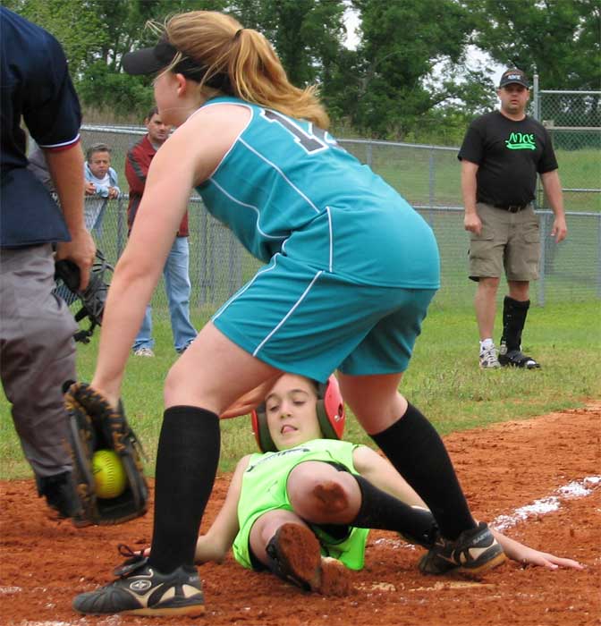 Reagan Bell NWE girs softball successfully slides into home plate as Mariah Albritton attempts the out